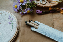 Lade das Bild in den Galerie-Viewer, Hitzestift für das Malen auf Kleidung in einem Etui neben Blumen